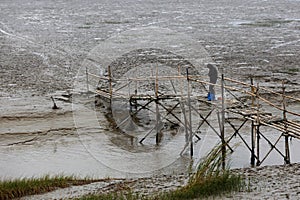 A man in the tidal flat river bridge on fishing