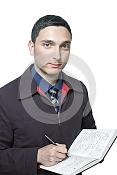 Man in tie writing in his planner