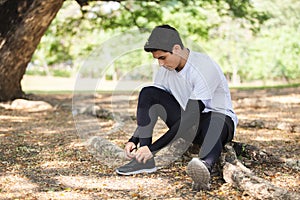 Man tied up shoes on stairs after running exercise in garden.