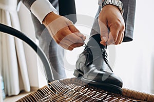 Man ties his shiney new black leather business shoes photo