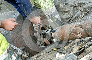 Man tightens a machine in the mud