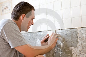 Man Tiling A Wall