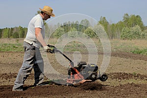 A man tilling ground with motor-cultivator