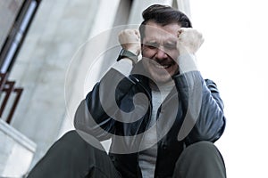 a man at the time of a panic attack sits in the city on the steps