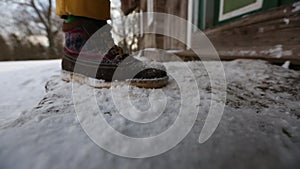 Man tinkers around the door in winter, walks over and shakes snow off his shoes