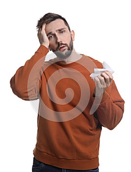 Man with tissue suffering from cold on white background