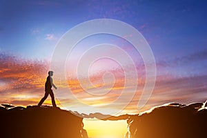 Man about to croos precipice between mountains over another man photo