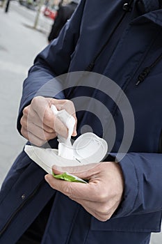 Man about to disinfect his hands with a wet wipe