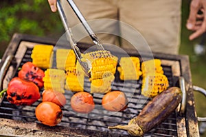 Man with tongs cooking on a back yard barbecue