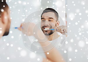 Man with toothbrush cleaning teeth at bathroom