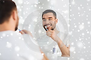 Man with toothbrush cleaning teeth at bathroom