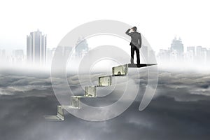 Man on top of money stairs looking at cityscape cloudscape