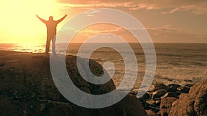 Man on top of mountain enjoying ocean coast view