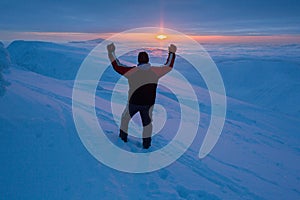 Man at the top of mountain during epic sunrise