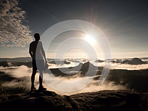 Man at the top of a mountain looking the misty landscape. Feel free