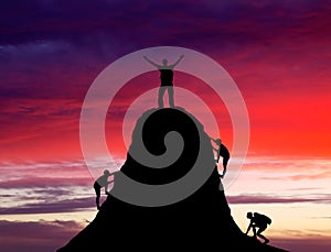 Man on top of the mountain and the other people to climb up. photo