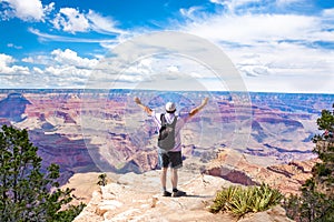 Man on top of the mountain with raised arms.