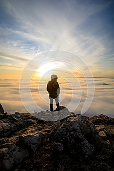 Man on top of mountain watching the sunset