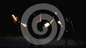 Man with a torch breathes fire. Two men spinning chains of fire. Fire show