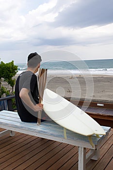 Man with a torch used in large sporting event and surfboard. In Japan