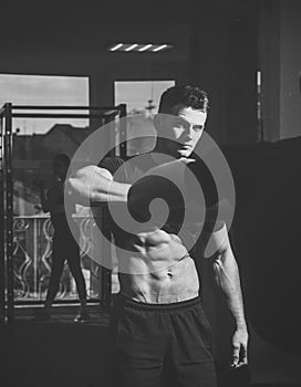 Man with torso, muscular macho and his reflexion in mirror background. Sportsman, athlete with muscles looks attractive
