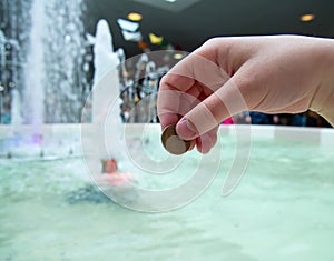 A man tosses a coin into a fountain photo