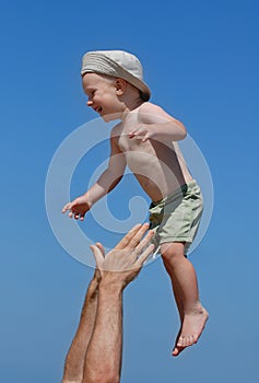 Man tossing little boy