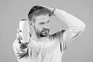 Man touch healthy hair with shampoo bottle in hand