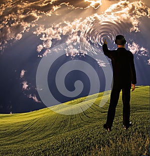 Man touches sky in landscape creating ripples