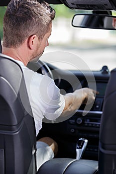 man touching car dashboard