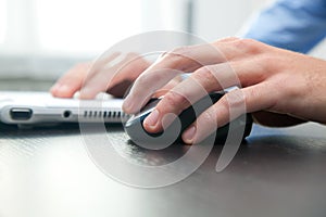 Man touching computer mouse and typing on a pc