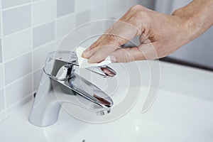 Man touching the faucet with a piece of paper