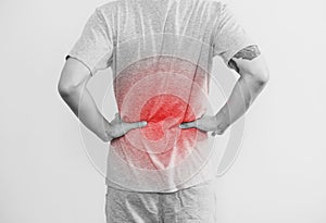 A man touching his back, with red highlight. Back pain, backache and waist pain