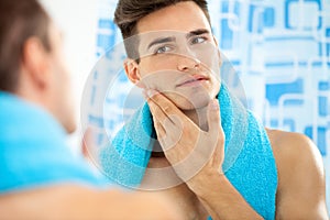 Man touching his face after shaving