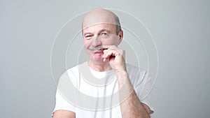 Man touching his mustache twisting them, thinking