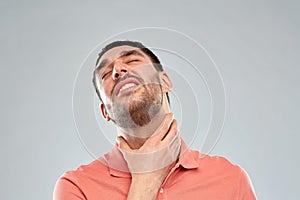 Man touching neck and suffering from throat pain