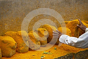 Man touching saffron colored stones, Maharashtra, India