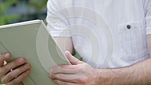 Man touching screen on modern digital tablet pc outdoors.