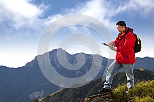 Man touching the tablet pc on the mountain