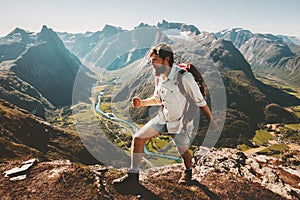 Man tourist with backpack hiking on mountain ridge