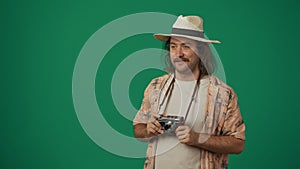 Man tourist in casual clothing and straw hat with amazed face expression holding old film camera, looking away. Isolated