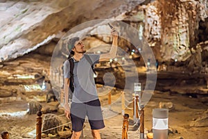 Man tourist in Hang Sung Sot Grotto Cave of Surprises, Halong Bay, Vietnam