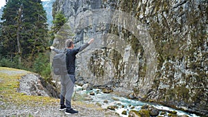 Man tourist hiker with backpack enjoying scenic view mountain river landscape. Travel hiker looking away. Travel, people