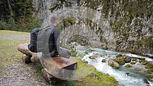 Man tourist hiker with backpack enjoying scenic view mountain river landscape. Travel hiker looking away. Travel, people