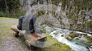 Man tourist hiker with backpack enjoying scenic view mountain river landscape. Travel hiker looking away. Travel, people