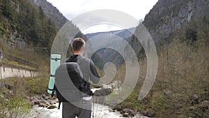 Man tourist hiker with backpack enjoying scenic view mountain river landscape. Travel hiker looking away. Travel, people