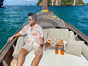 Man tourist in private longtail boat trip to island with exotic food picnic, Krabi, Thailand. landmark, destination, Asia Travel,