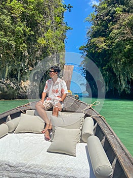 Man tourist in private longtail boat trip to Lagoon koh hong near Hong island, Krabi, Thailand. landmark, destination, Asia Travel
