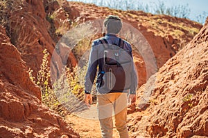 Man tourist in red canyon, resumption of tourism concept