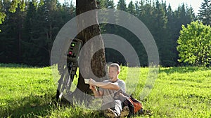 Man tourist resting with a bicycle in the summer forest on a sunny day .